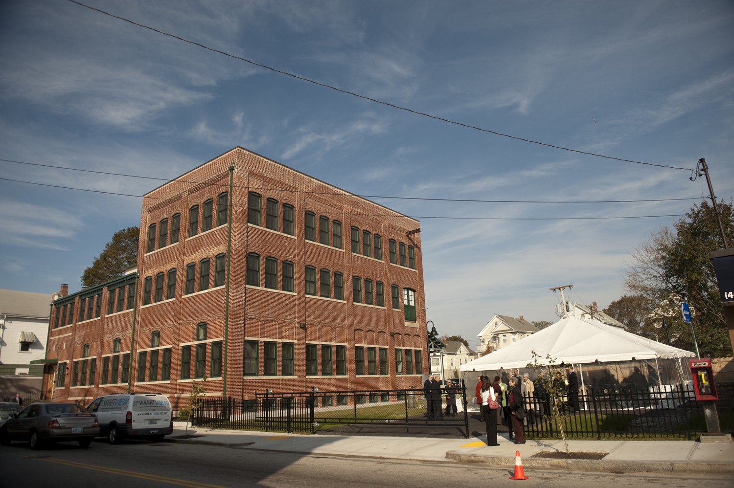 OpenDoors' three-story brick building in Providence with a tent set up outside
