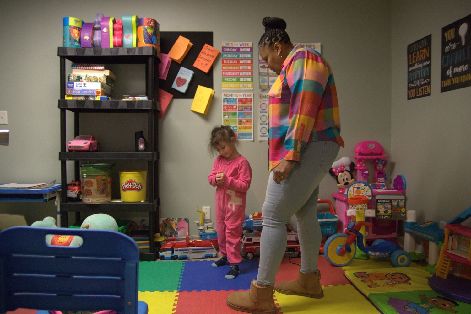 Staff member and a child in the colorful playroom at the She Thrives house