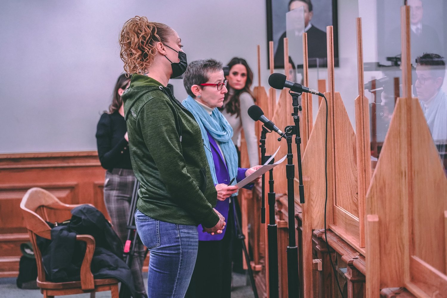 People testifying at microphones during a legislative hearing