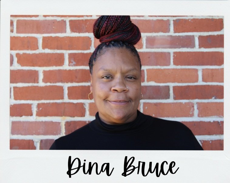 Portrait of Deputy Director Dina Bruce against a brick wall