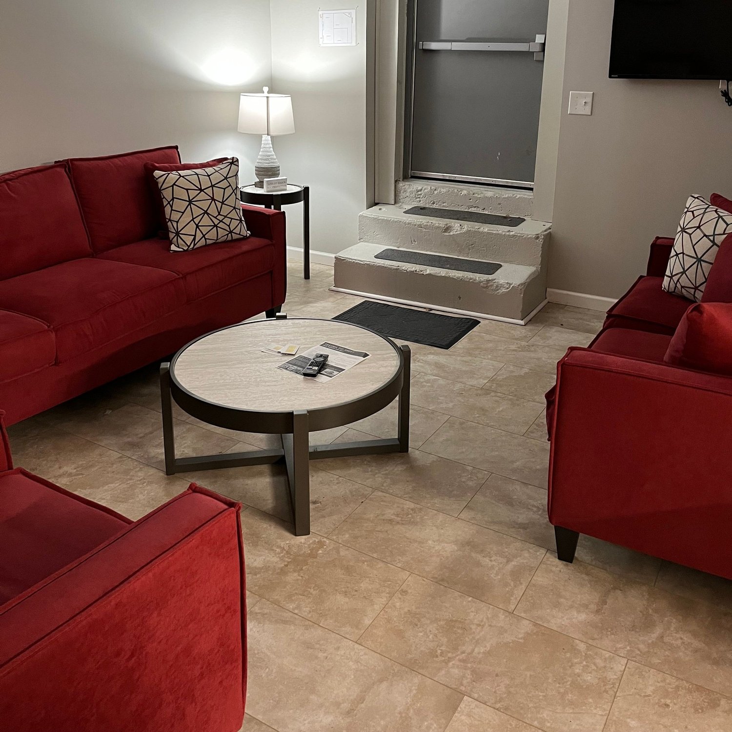 Living room with red sofas at the Foundations transitional house