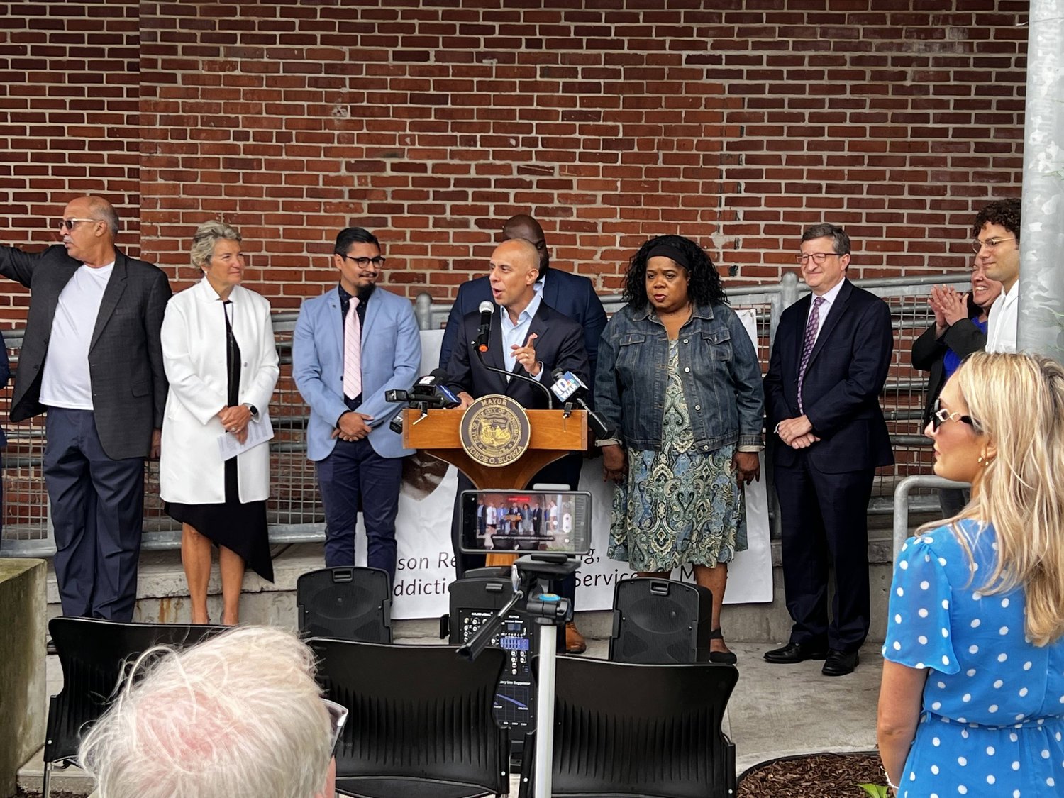 Officials at a podium announcing the driver's license program