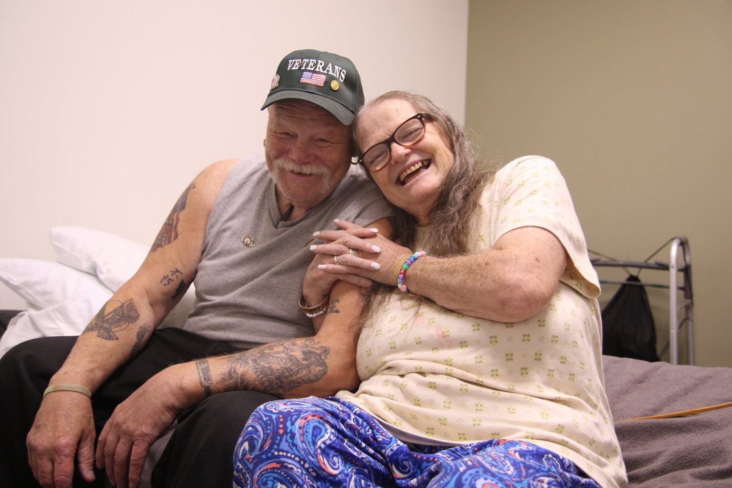 Keven and Jayne sitting together on a bed at the OpenDoors shelter