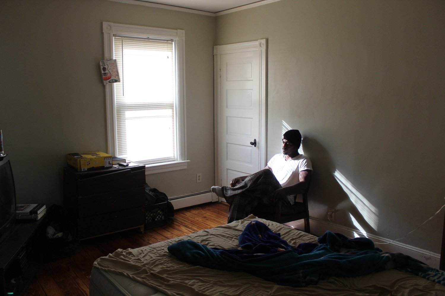 Resident sitting in his bedroom at the men's transitional house
